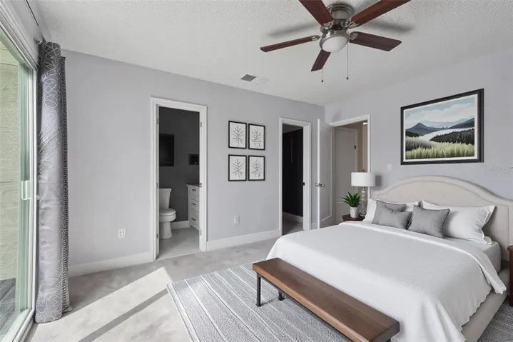Virtually Staged Primary Bedroom with view to primary bathroom and walk-in Closet
