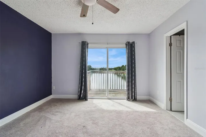 Primary Bedroom with view to the Balcony that overlooks the pond