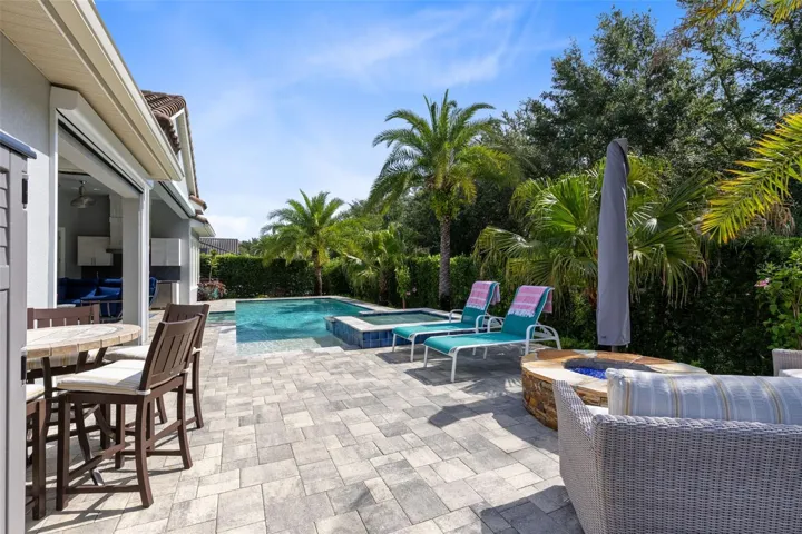 Spacious brick paver lanai with a fire pit (natural gas) and additional seating areas