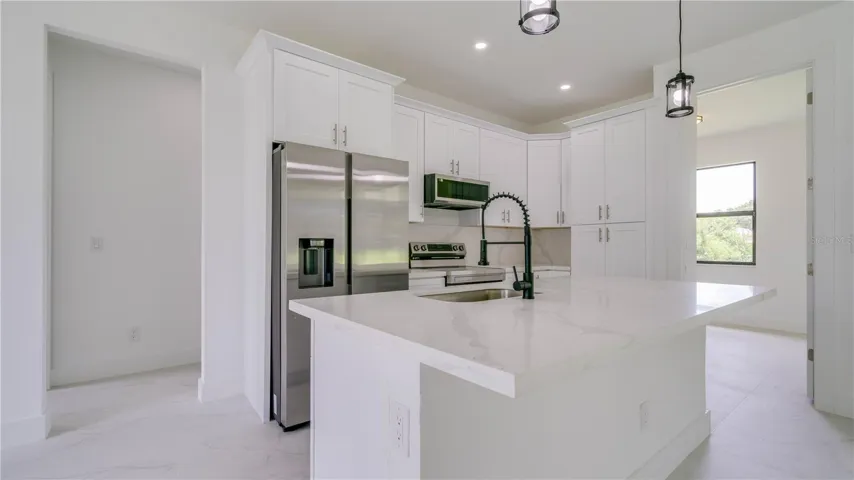 Gorgeous cabinetry and quartz countertops & Island. The open door to the right leads to your office/den!