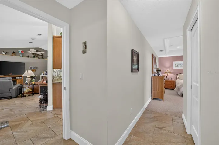 Hallway toward primary bedroom to right and living room to left