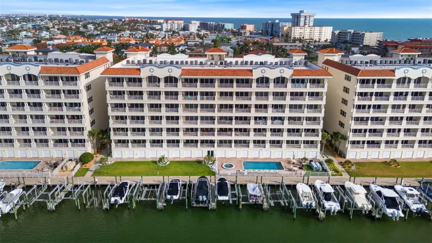 Exterior waterfront of unit 604 , with private docks, pool, spa, kayak, and fishing pier on BOCA CIEGA BAY leading to the GULF OF MEXICO