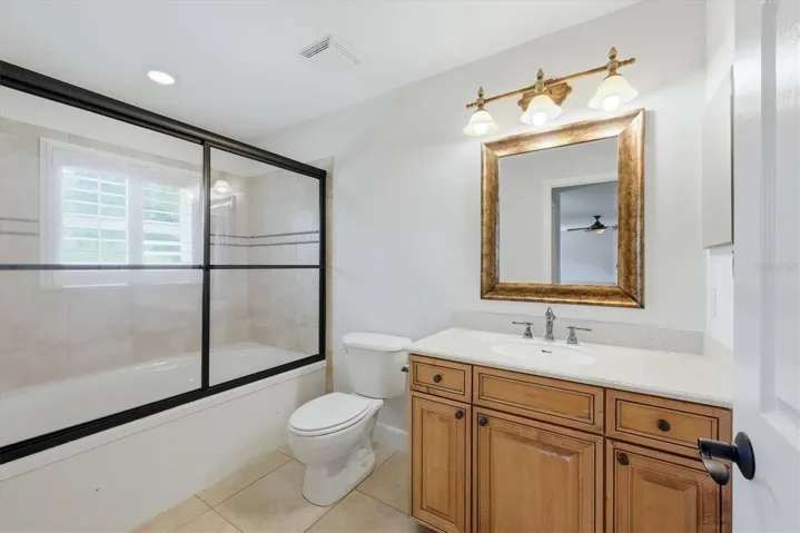 Guest bathroom with tub-shower combination and wood vanity
