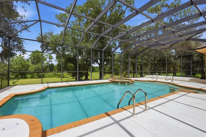 Screened swimming pool surrounded by mature trees