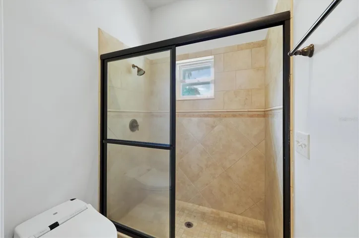 Walk-in tiled shower with glass enclosure