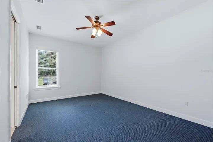 Secondary bedroom with ceiling fan and natural light