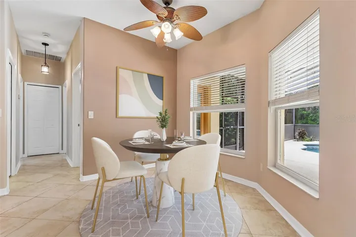 The adjoining breakfast nook surrounded by windows overlooking the pool, makes every meal feel special. Virtually Staged
