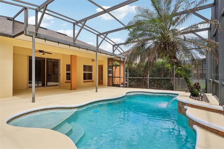 Step outside to your own BACKYARD OASIS where the covered patio, sparkling in-ground pool with a beautiful WATERFALL FEATURE, new light fixtures, and pool pump replaced in 2017 are all enclosed within an EXPANSIVE SCREENED LANAI, creating the perfect setting for relaxing weekends, family gatherings, or entertaining guests.