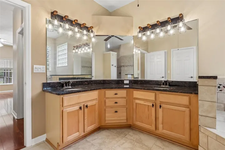 A SPA-INSPIRED EN SUITE BATH is complete with dual sinks with makeup station, a relaxing ROMAN TUB, an oversized walk-in tiled shower with built-in bench, and a private water closet.