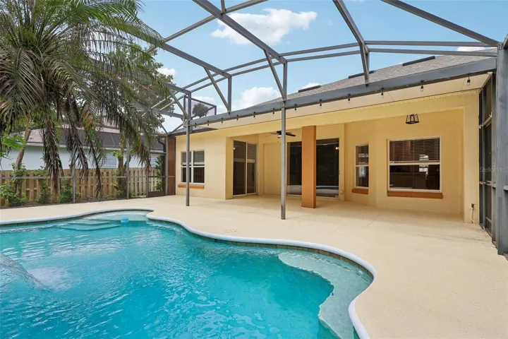Step outside to your own BACKYARD OASIS where the covered patio, sparkling in-ground pool with a beautiful WATERFALL FEATURE, new light fixtures, and pool pump replaced in 2017 are all enclosed within an EXPANSIVE SCREENED LANAI, creating the perfect setting for relaxing weekends, family gatherings, or entertaining guests.