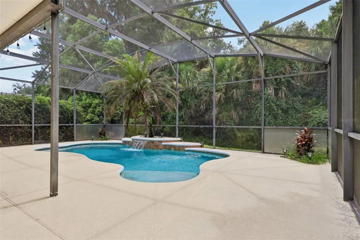 Step outside to your own BACKYARD OASIS where the covered patio, sparkling in-ground pool with a beautiful WATERFALL FEATURE, new light fixtures, and pool pump replaced in 2017 are all enclosed within an EXPANSIVE SCREENED LANAI, creating the perfect setting for relaxing weekends, family gatherings, or entertaining guests.