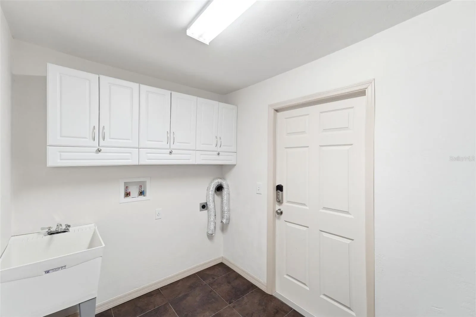 Functional laundry room with additional cabinetry for extra storage.