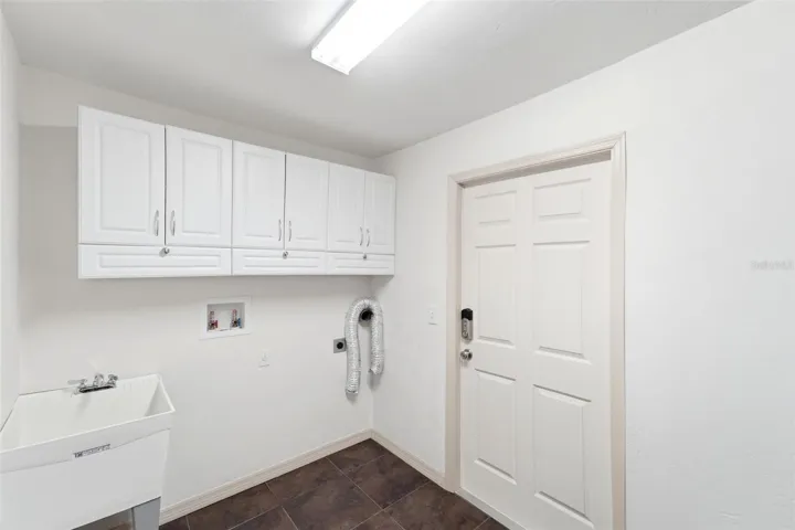 Functional laundry room with additional cabinetry for extra storage.