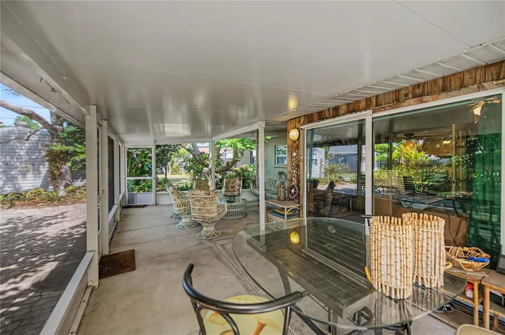 spacious covered, enclosed outdoor living area overlooking the tranquil side yard gardens