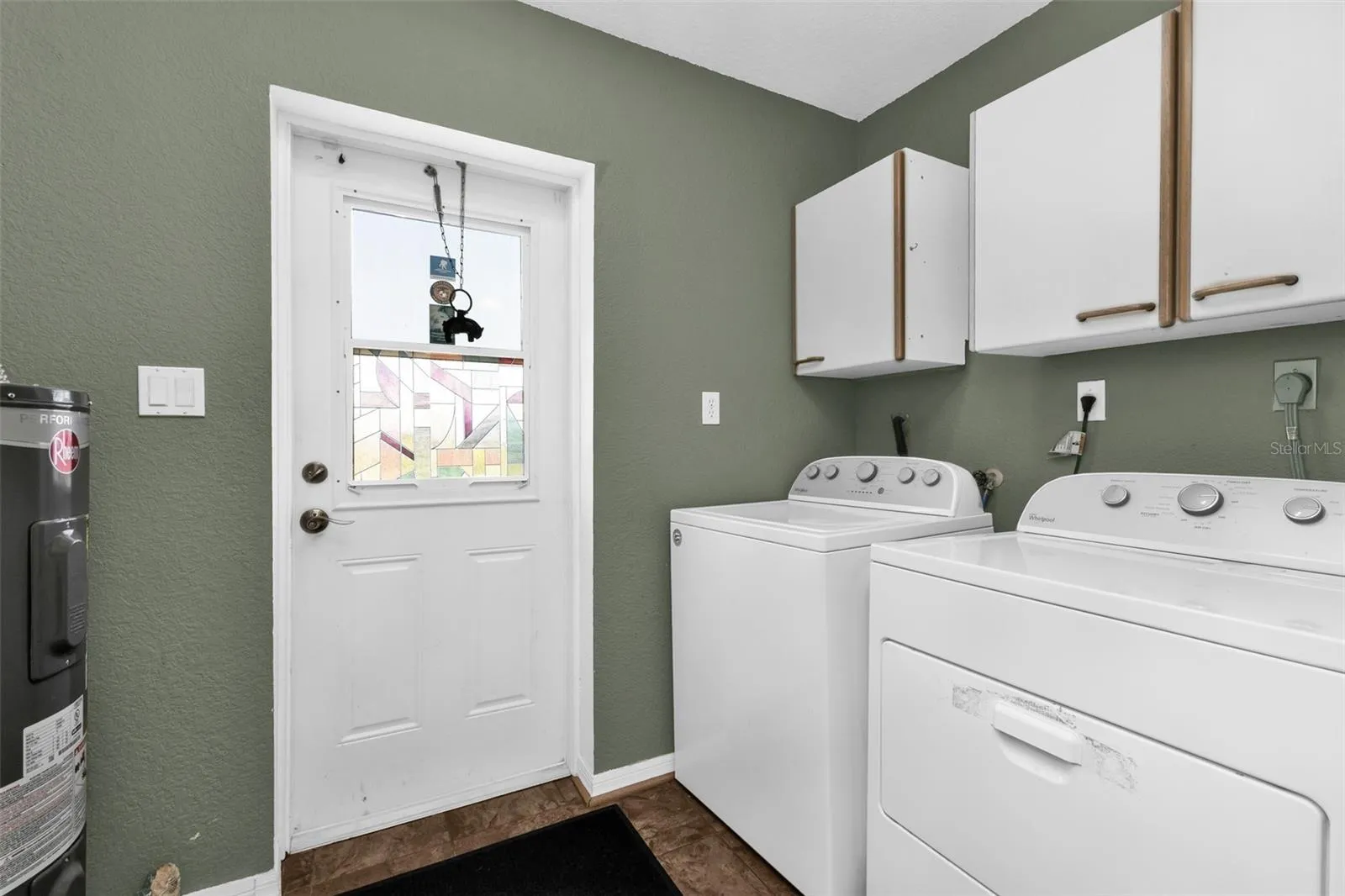 Laundry area with cabinets and access to the oversized parking pad on the left of the home.