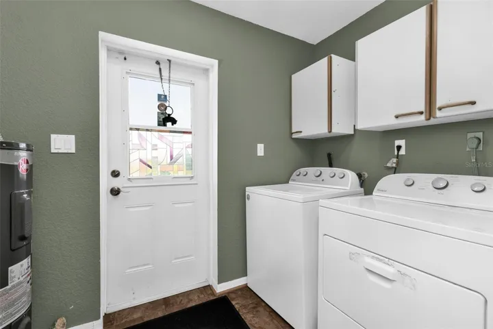 Laundry area with cabinets and access to the oversized parking pad on the left of the home.