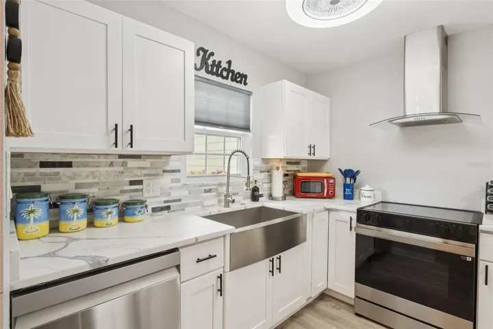 Kitchen with new quartz countertops, cabinets, backsplash, farmhouse sink, oven hood and all new SS appliances