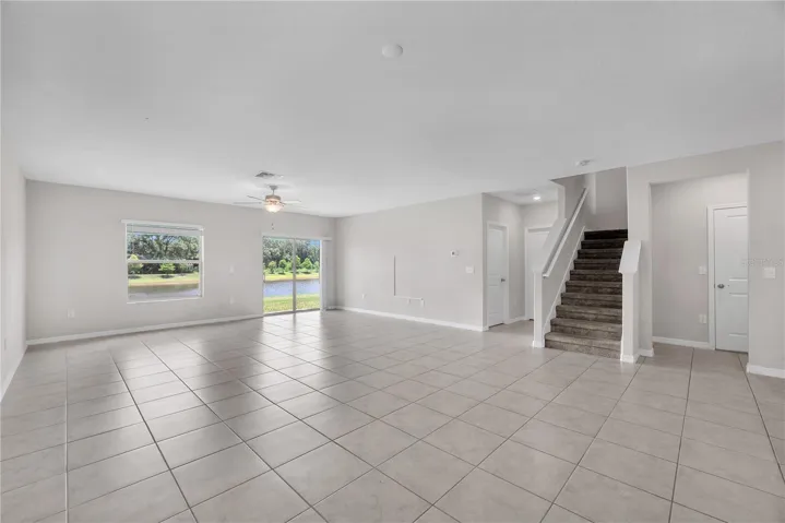 The first floor primary entrance and laundry room is to the left of the staircase and a convenient half bath and garage access is to the right of the staircase.