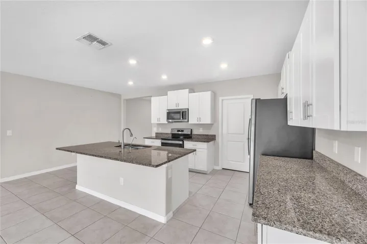 The kitchen island is a work space and provides additional seating.