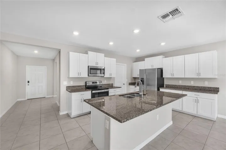Chef's kitchen is the centerpiece of the home, featuring a large center island with seating and granite countertops, abundant cabinetry, a walk-in pantry to keep everything organized