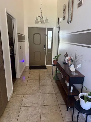 Spacious entry foyer, tile flooring, high ceilings.