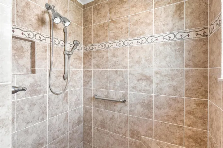 Primary Bath features double vanity sinks, granite countertops, and walk in tiled shower.