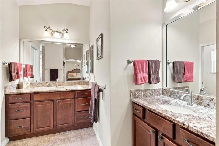 Primary Bath features double vanity sinks, granite countertops, and walk in tiled shower.