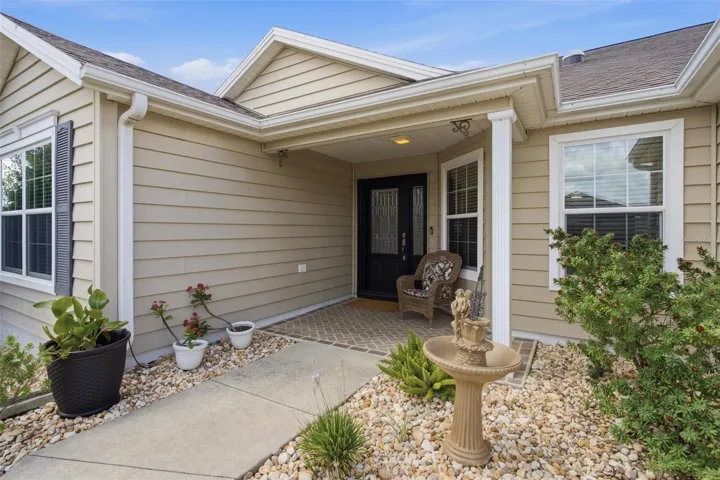 Exterior front entry into home features cover front porch.