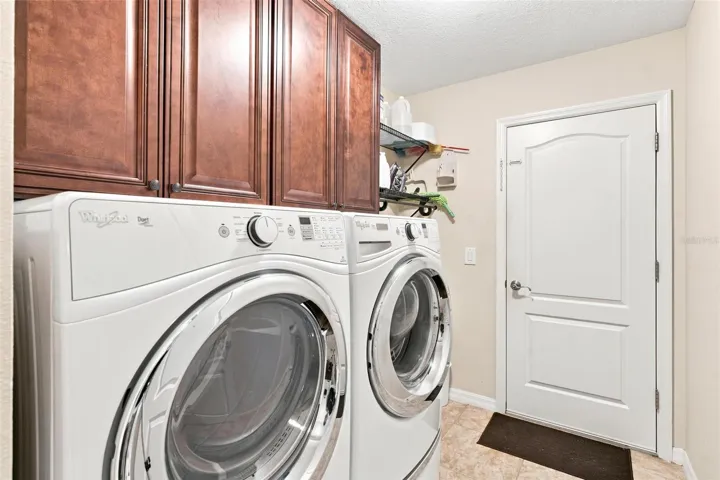 Interior utility room features cabinets for additional storage.