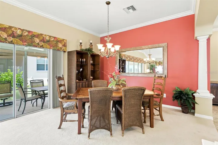 Dining Area overlooks the living room and kitchen and features sliders leading to the screen enclosed lanai.