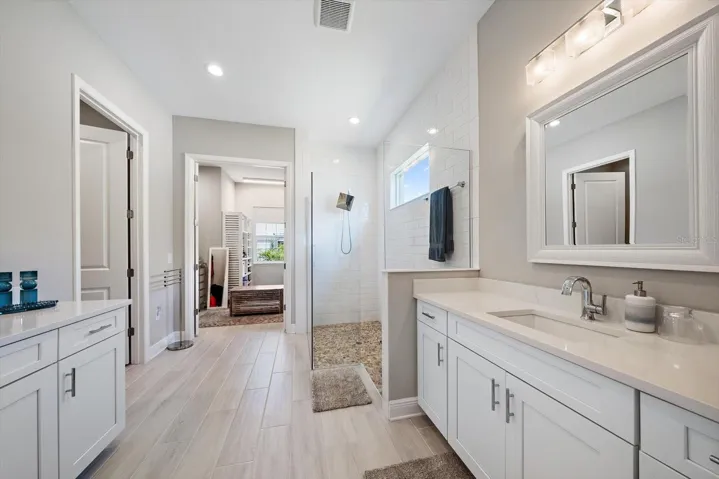 Ensuite bathroom with split vanities, walk-in shower shower, water closet, and huge walk-in closet.
