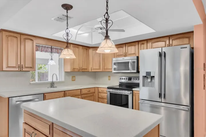 Kitchen with Corian countertops, wood cabinets, and Stainless Appliances