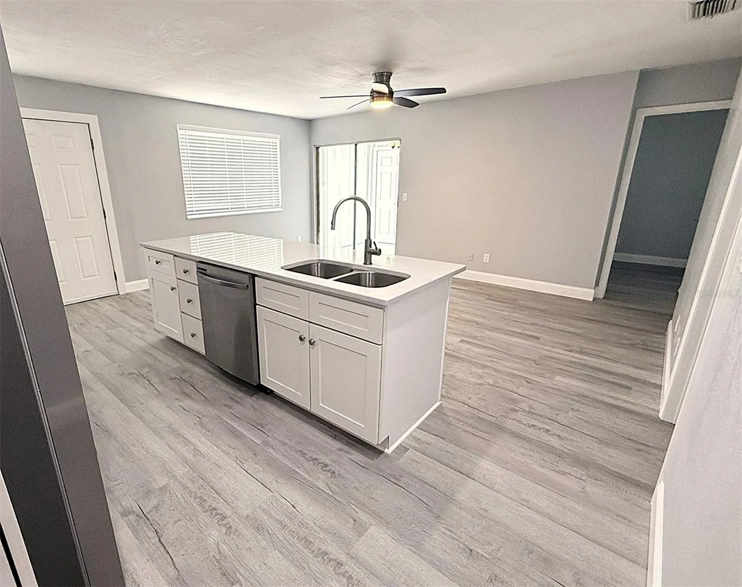 Kitchen with view of living room with sliders out to the porch and laundry