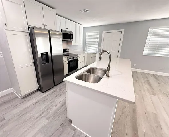 Kitchen with stainless steel appliances and solid surface countertops