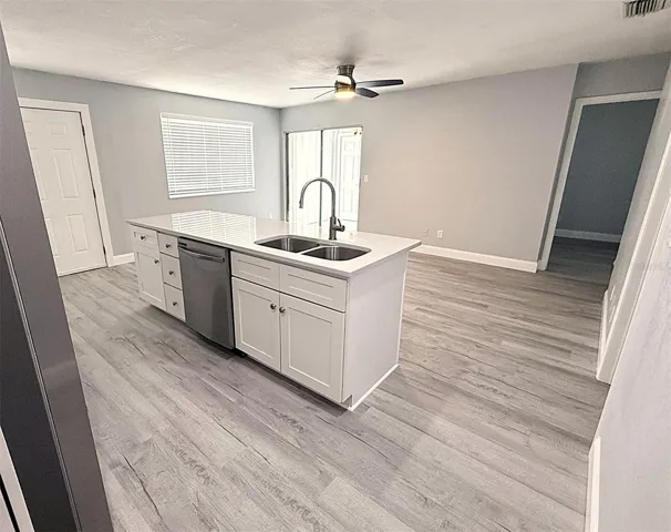Kitchen with view of living room with sliders out to the porch and laundry