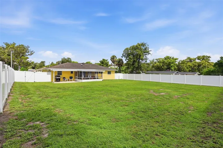 Rear view of home in huge fenced backyard.