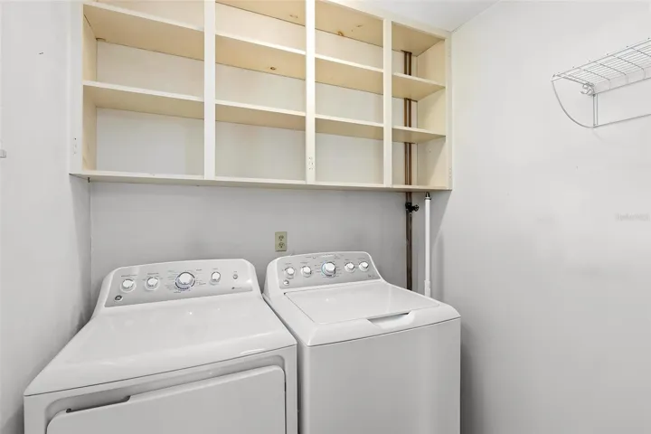 Indoor laundry room. The washer, dryer, and shelves all stay with your new home.