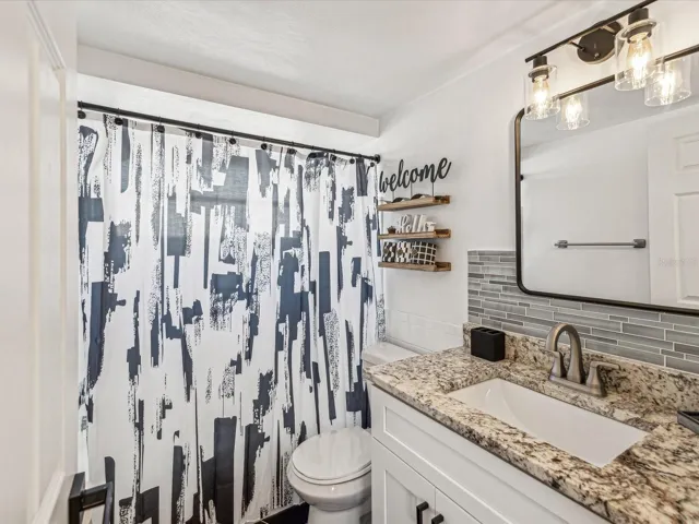 Bathroom #1 with granite vanity and tub/shower combo.