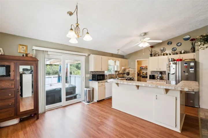 View of dining area, kitchen, and raised deck with hot tub