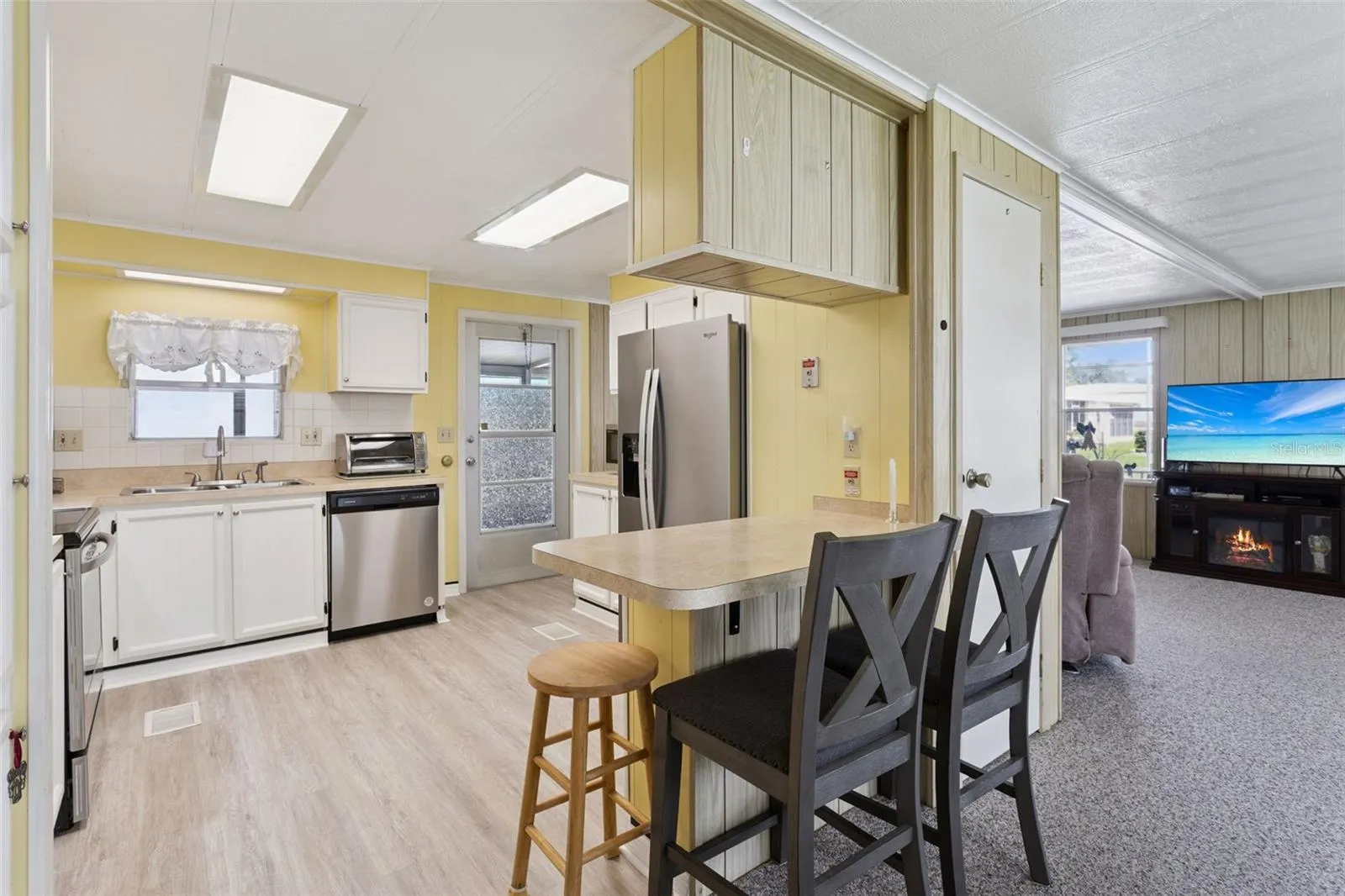 KITCHEN HAS A CONVENIENT BREAKFAST BAR AND NEWER APPLIANCES.