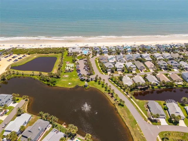 Aerial view of lake with fountain across from house