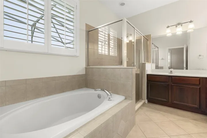 The spacious primary ensuite offers dual vanities, abundant cabinet and counter space, a relaxing soaking tub, and a separate walk-in shower.