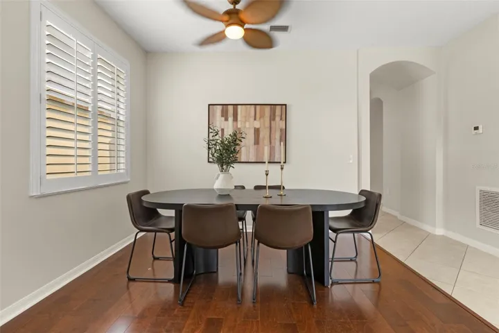 Formal dining room with gleaming laminate wood floors, white custom shutters
