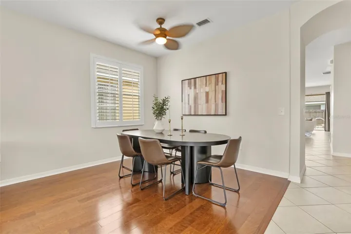 Formal dining room with gleaming laminate wood floors, white custom shutters