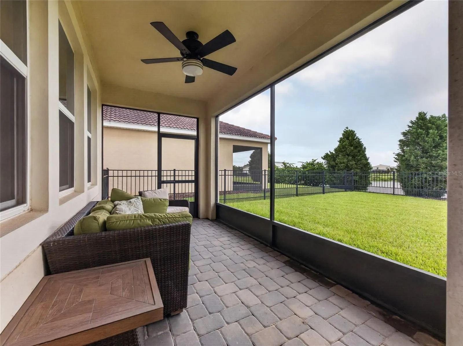 Screened-in pavered lanai overlooking a fully fenced backyard with beautiful golf course views—the perfect spot to relax and enjoy Florida living.
