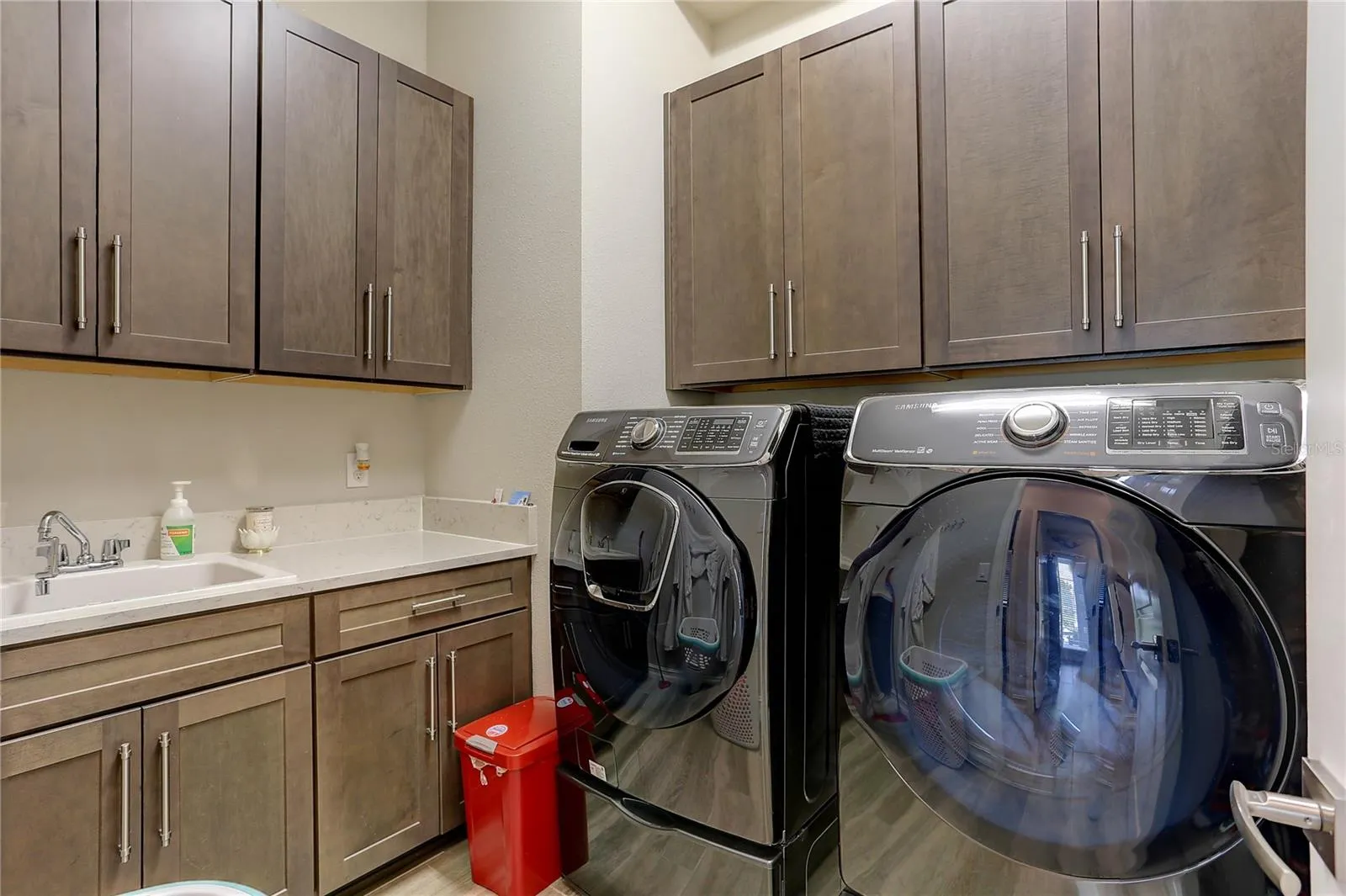 Laundry center with cabinets, sink, storage closet