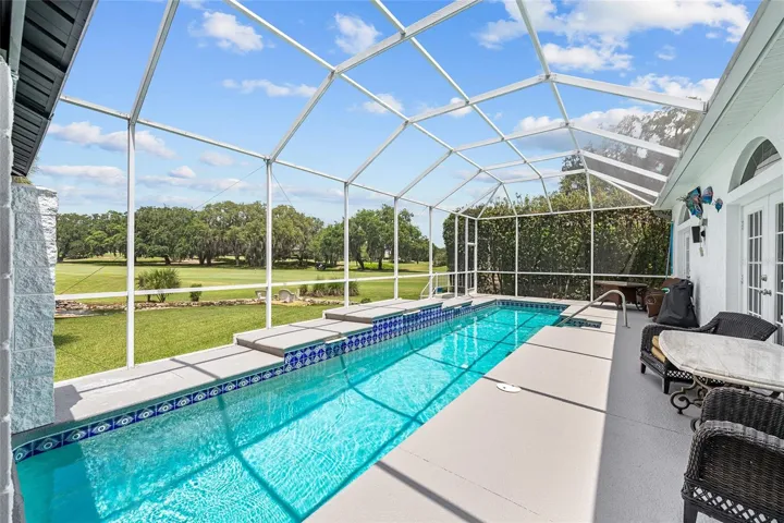 A long swimming lap pool w/ waterfall, covered Pergola seating area, and screened enclosure create a comfortable setting for year-round Florida enjoyment.