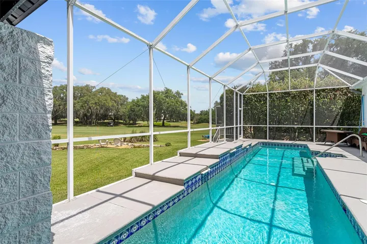 The spacious screened pool area provides ample room for lounge furniture, outdoor dining, and entertaining beside the water.