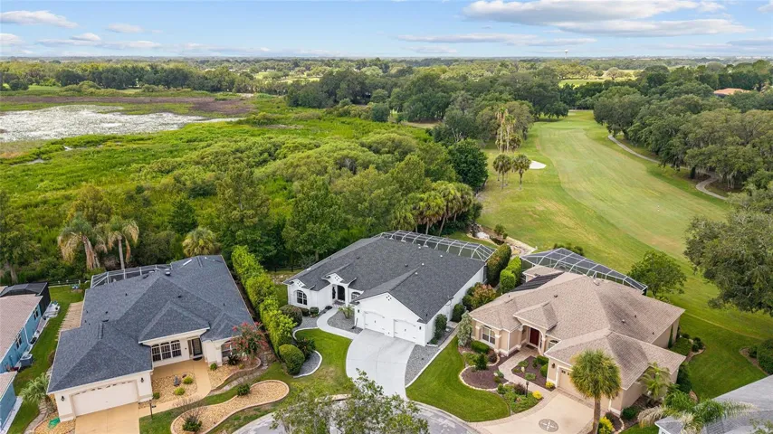 Aerial overview emphasizes the property’s exceptional fairway setting (SAFE ZONE), screened pool area, mature trees, and surrounding scenic landscape.