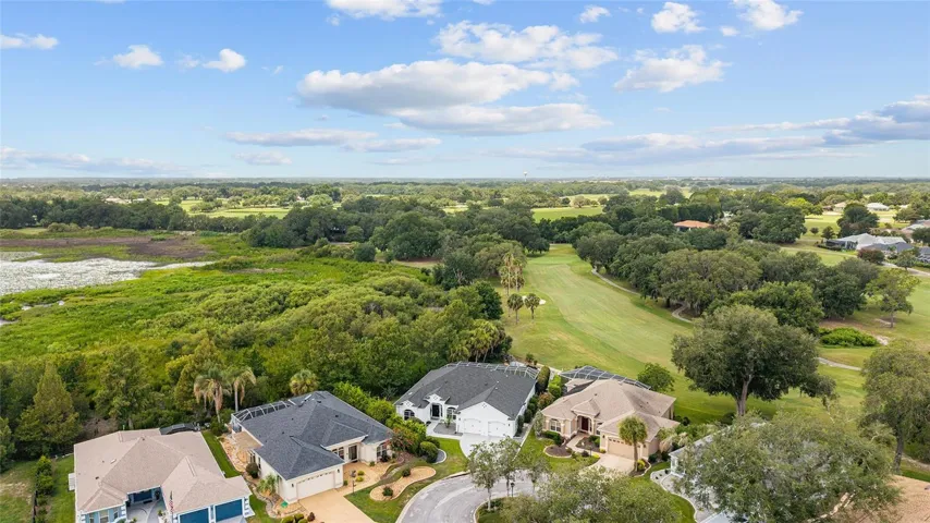 Elevated perspective captures the home’s prime position near the fairway, with expansive treetop and water views extending into the distance.